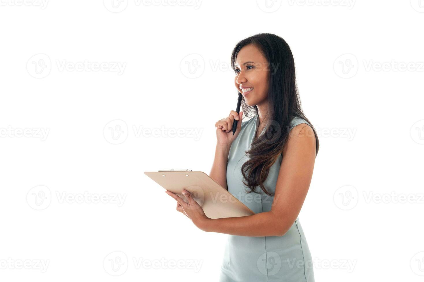 portret van een glimlachen gemengd ras Aziatisch vrouw Holding documenten met pen terwijl op zoek omhoog geïsoleerd over- wit achtergrond foto