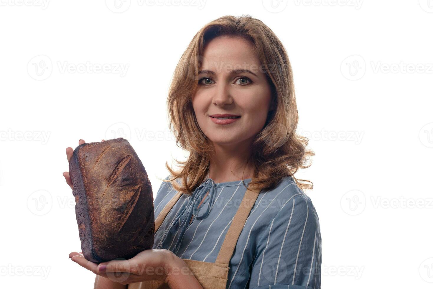 dichtbij omhoog portret van vrouw in schort tonen een zuurdesem eigengemaakt brood, geïsoleerd Aan wit achtergrond foto