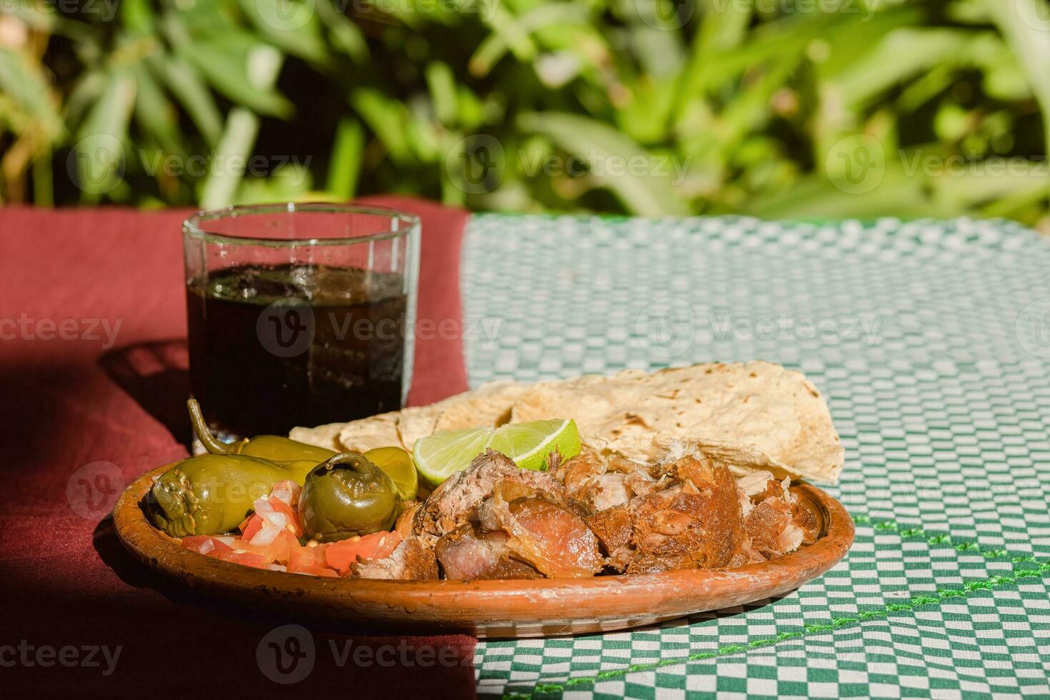 de Mexicaans carnitas, een heerlijk voedsel, is geserveerd met divers specerijen Aan een tafel met serviesgoed foto