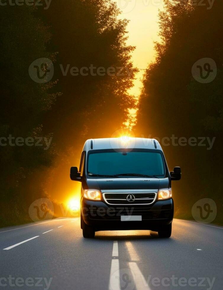 een busje het rijden naar beneden een weg met de zon instelling achter het foto