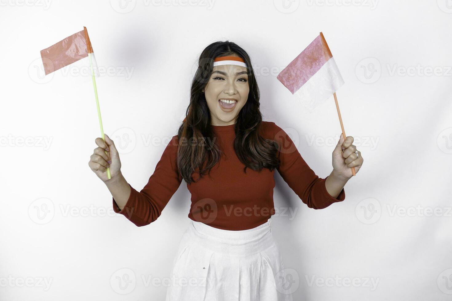 opgewonden jong Aziatisch vrouw vieren Indonesisch onafhankelijkheid dag Holding de Indonesisch vlag geïsoleerd Aan wit achtergrond foto