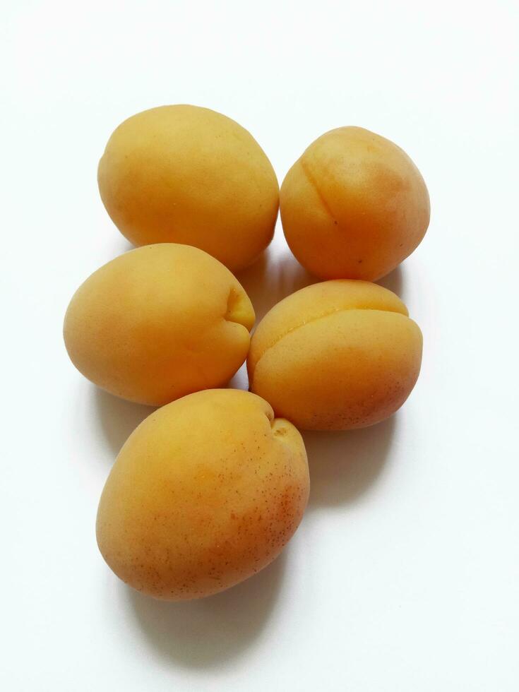 rijp abrikozen Aan wit achtergrond foto