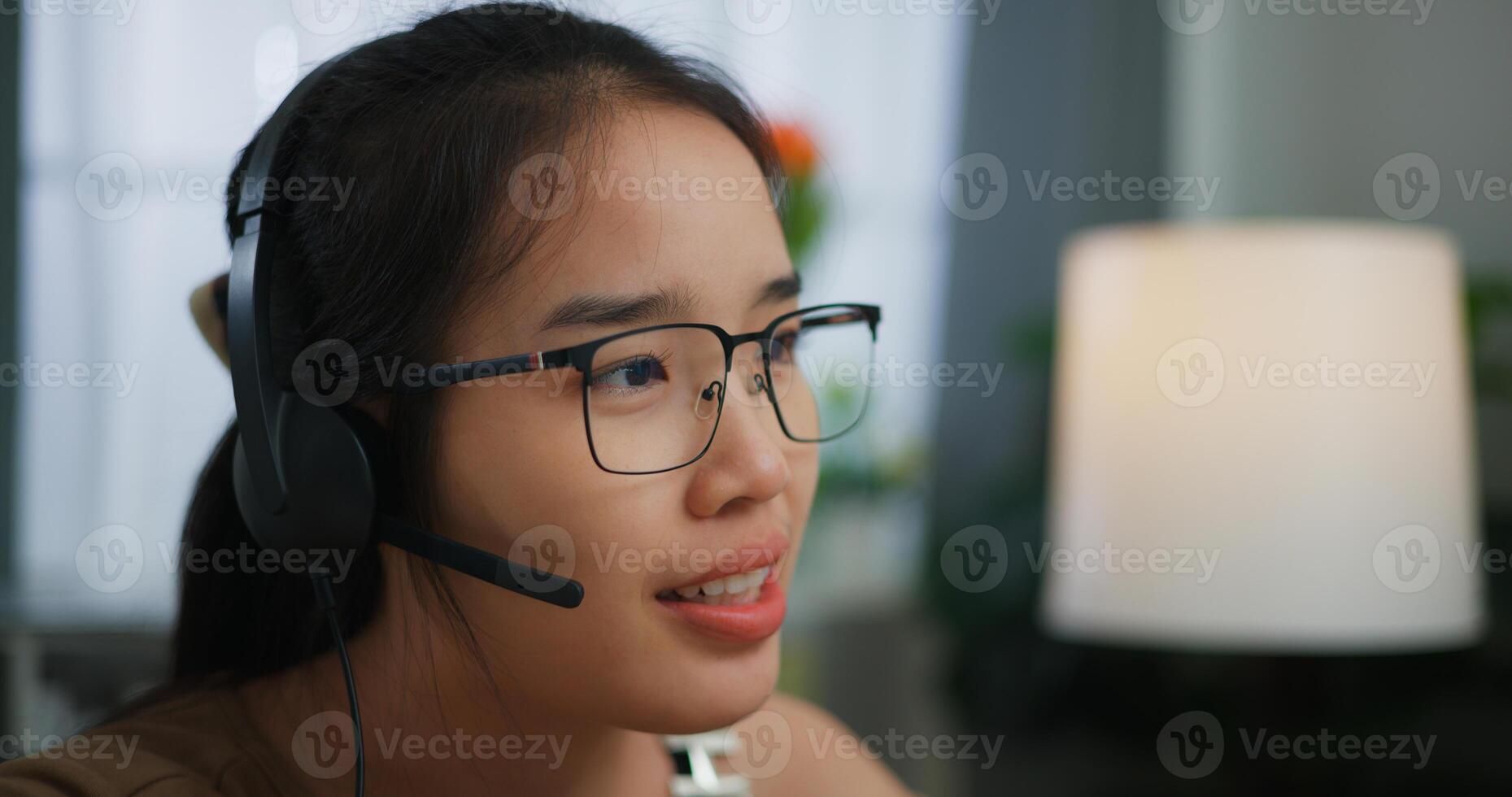 jong Aziatisch vrouw vervelend bril gebruik makend van een laptop Aan een bureau foto