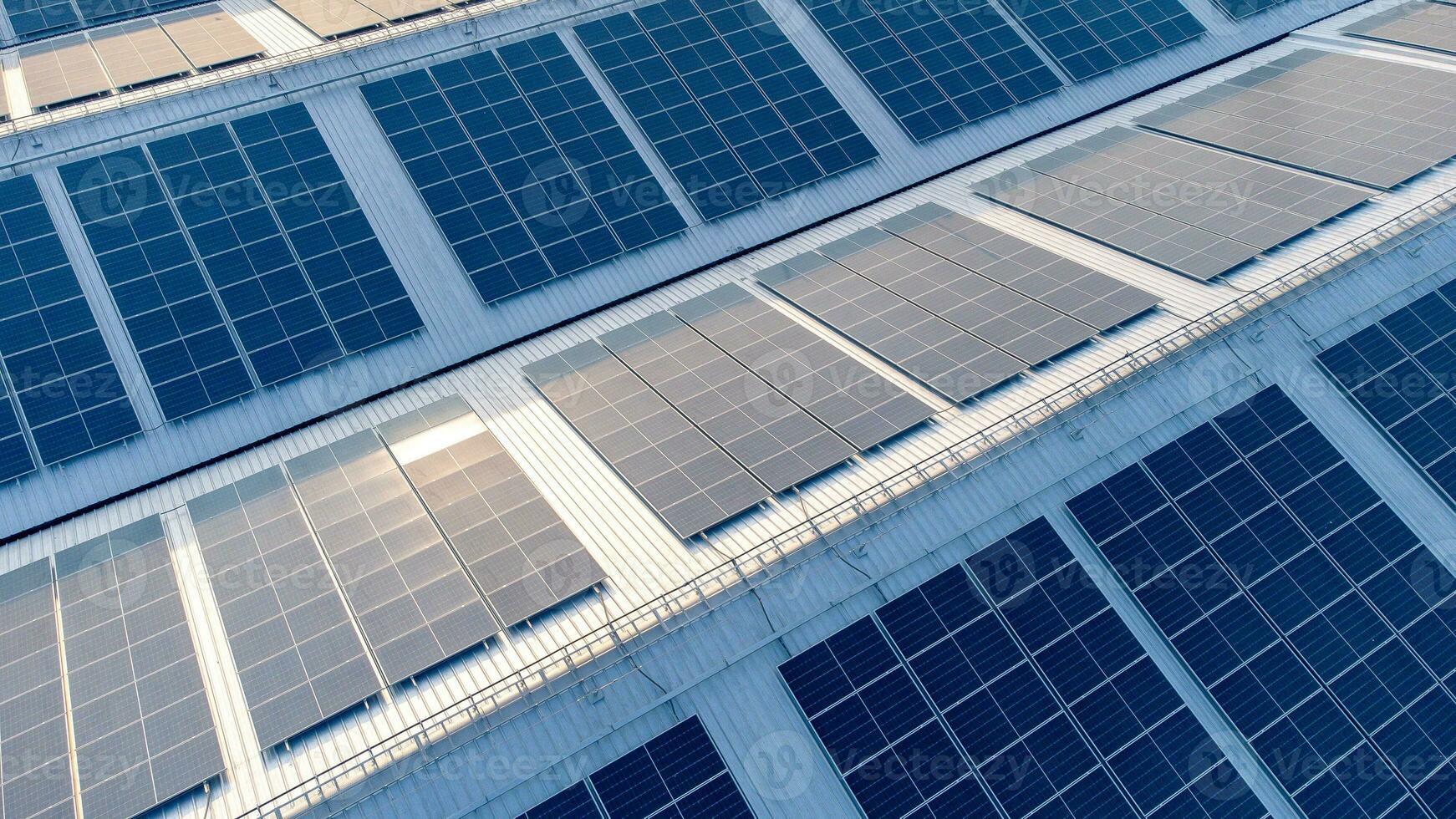 toekomst groen energie en duurzame elektriciteit hulpbron concept. buitenshuis focus Aan zonne- panelen Aan daken of fotovoltaïsche energie van fabrieken door drone. industrieel dak met zonne- cel rooster met blauw toon. foto