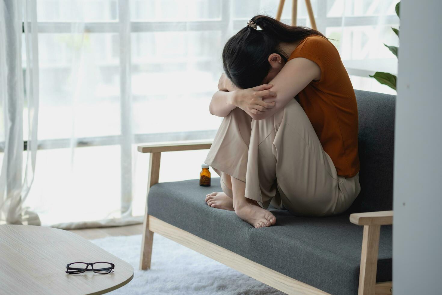 jong vrouw zittend Aan de sofa met een groot aantal van pillen depressief vrouw wil naar doden haarzelf door drug overdosis, depressie concept. foto