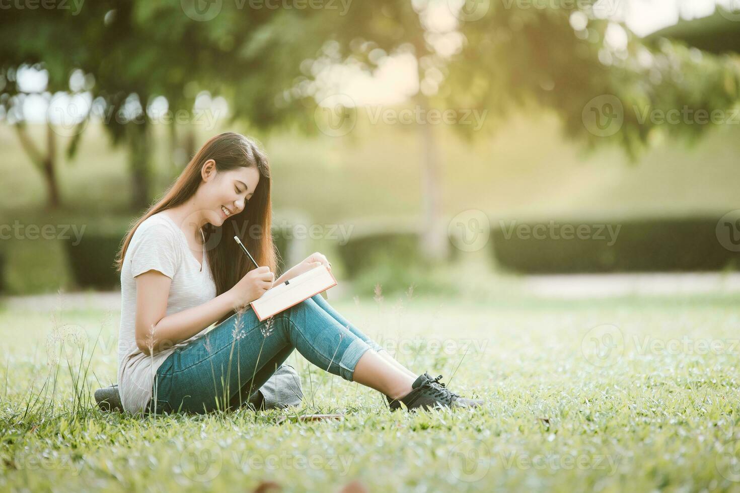 gelukkig vrouw leerling zittend Bij park en schrijven iets Aan notitieboekje, onderwijs concept foto