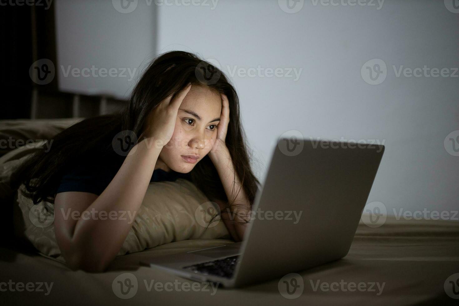 jong Aziatisch Dames werk laat Bij nacht benadrukt uit. moe en uitgeput van werken Aan computer laptop in de slaapkamer. foto