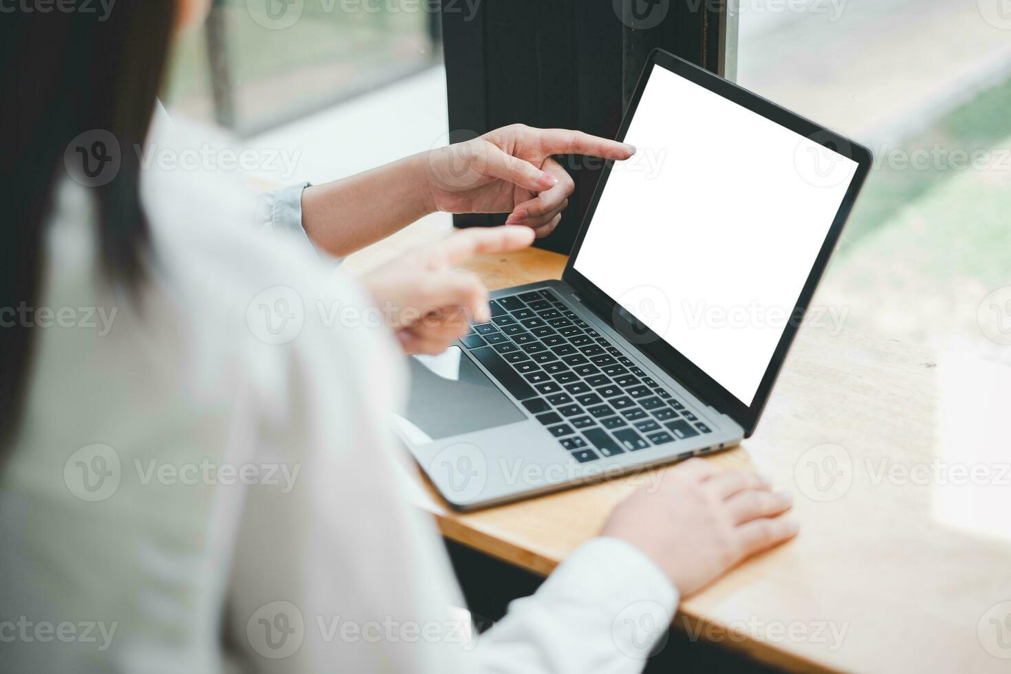 detailopname terug visie van twee bedrijf vrouw werken Aan blanco scherm laptop computer, op zoek Bij de scherm. kantoor arbeider gebruik makend van een notitieboekje computer. foto