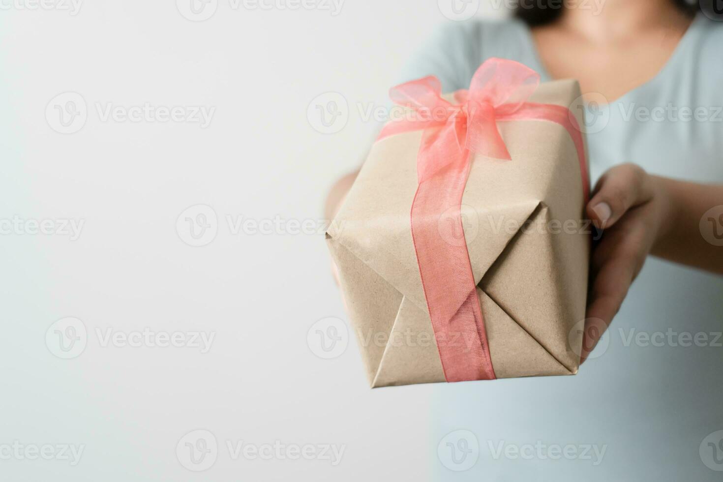 vrouw draag- geschenk papier doos stropdas schattig lint voor speciaal gelegenheid. levering Bezig met verzenden Cadeau naar iemand speciaal naar dank of verrassing. foto