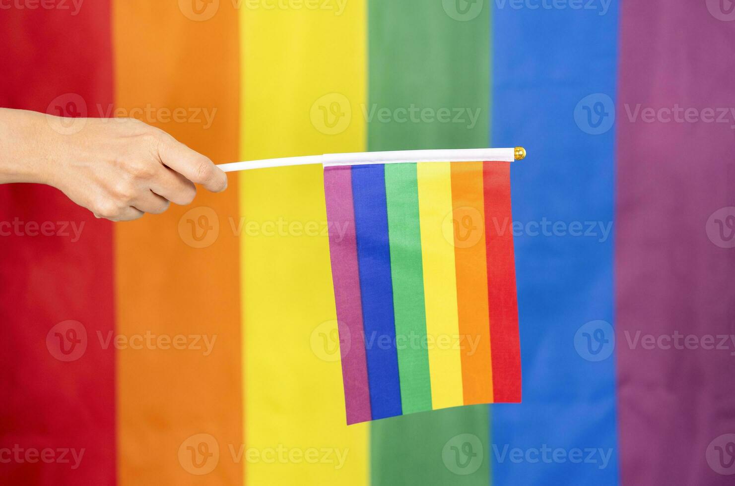 hand- Holding kleurrijk regenboog homo vlag, symbool van lgbt mensen, verscheidenheid van geslachten liefde, romantiek, tolerantie,viering,concept van lgbtq gemeenschap gelijkheid beweging, lhbt gelukkig trots maand foto