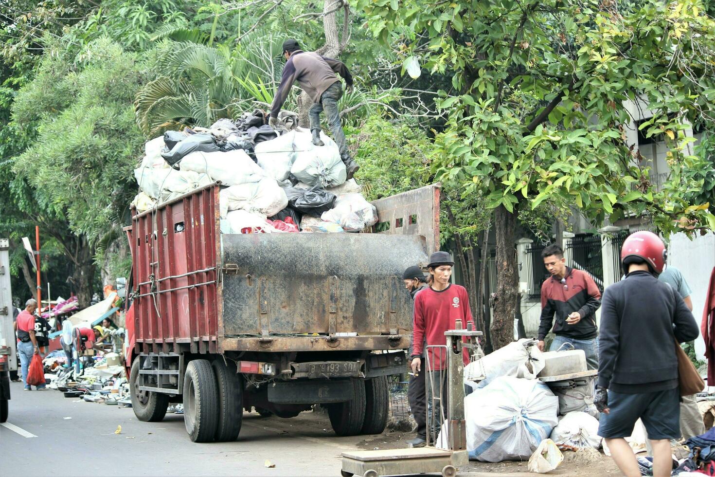 Jakarta, Indonesië-18 juni 2023 mensen sorteren gebruikt goederen van binnen de vrachtauto foto