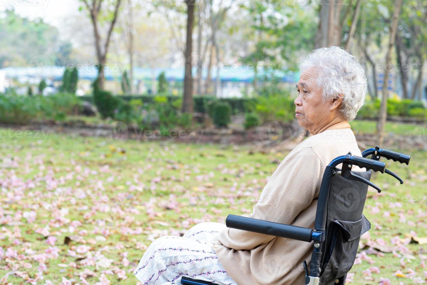 Aziatische senior of oudere oude dame vrouw patiënt pijn haar knie op rolstoel in park, gezond sterk medisch concept. foto