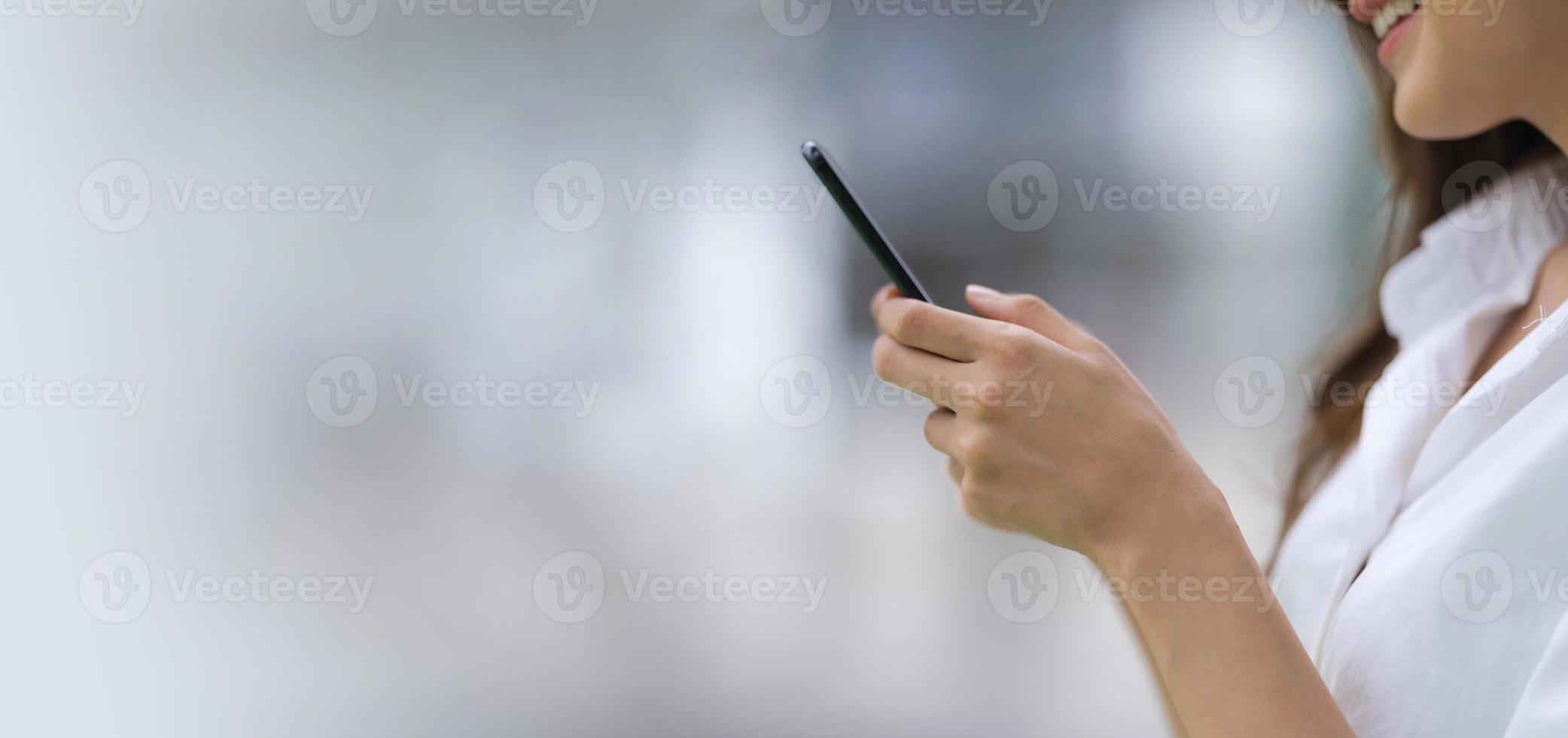 buitenshuis portret van gelukkige jonge vrouw met behulp van een telefoon foto