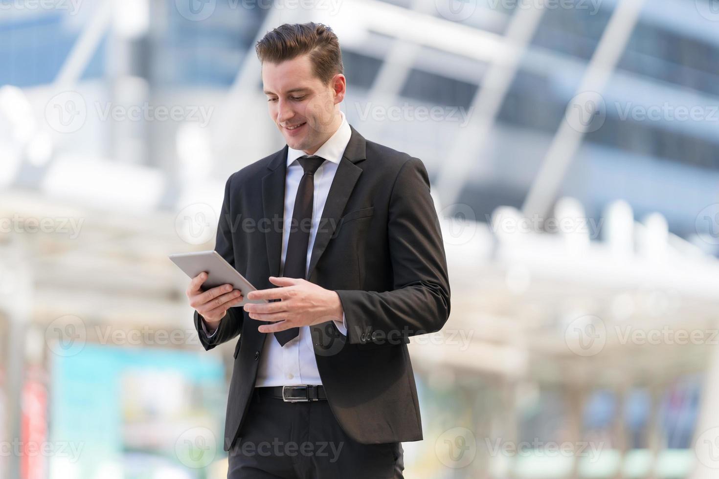 portret van lachende zakenman die op tablet gebruikt foto