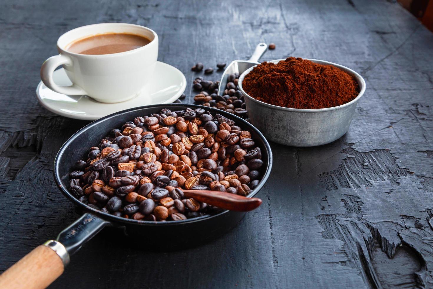 gebrande koffiebonen met koffiepoeder en koffiekopjes. foto