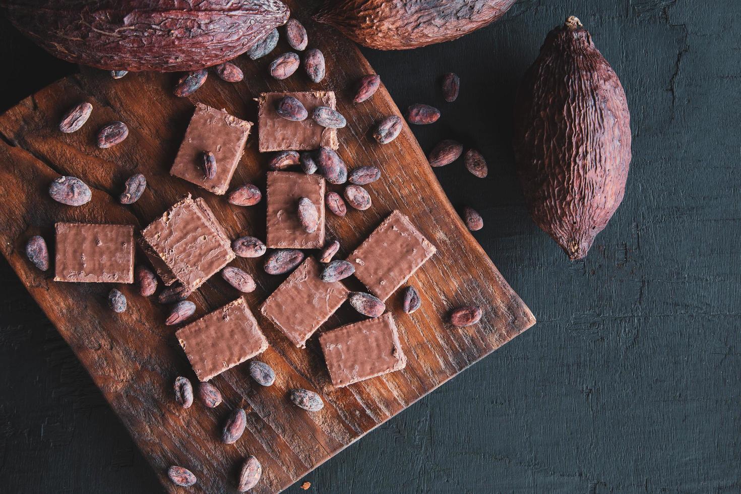 chocolade en cacaobonen met cacao op een zwarte achtergrond foto