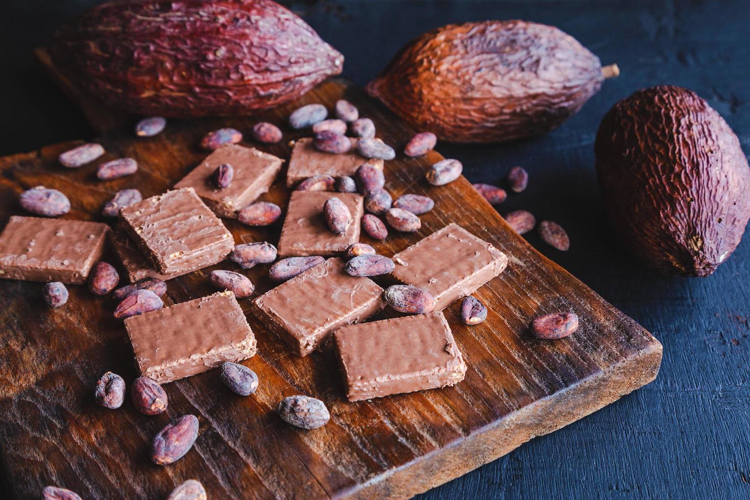 chocolade en cacaobonen met cacao op een zwarte achtergrond foto