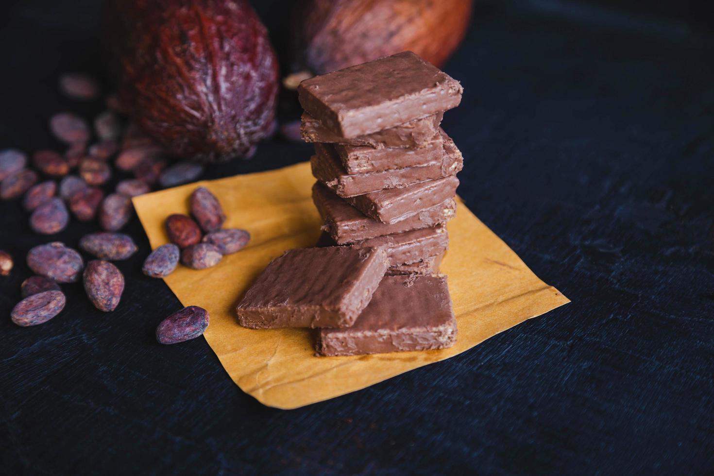 chocolade en cacaobonen met cacao op een zwarte achtergrond foto