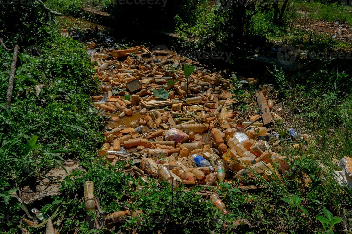 aambeien van verspilling links over- van plastic drank flessen in sloten welke oorzaak water naar verstoppen en niet stromen kan oorzaak overstromingen foto