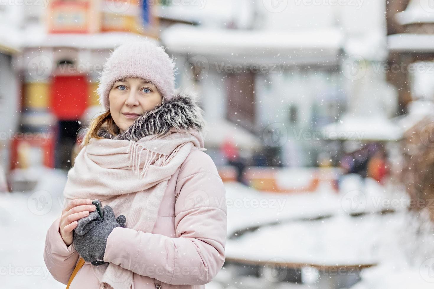 portret van een jonge vrouw in warme winterkleren buitenshuis tijdens het reizen. wintertijd, sneeuw foto