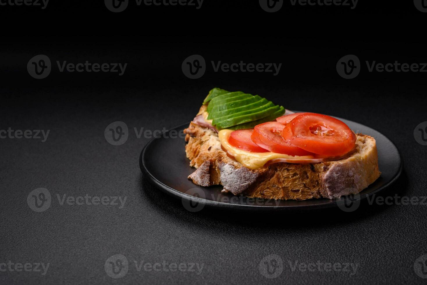 heerlijk voedzaam gegrild geroosterd brood met ham, kaas, tomaten en avocado foto