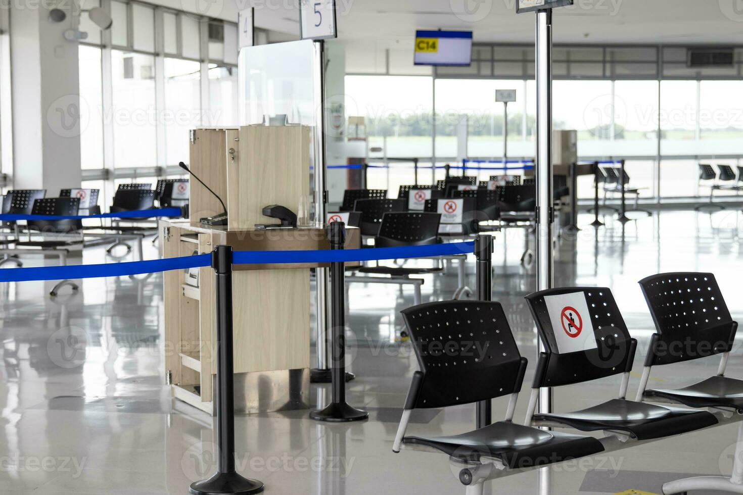 leeg wachten kamer Bij een luchthaven gedurende covid 19 pandemisch met sociaal afstand nemen tekens Aan stoelen foto