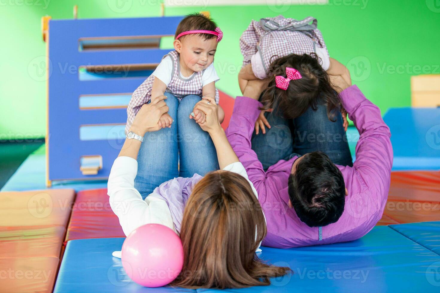 jong ouders spelen met hun dochters. vroeg stimulatie voor peuters en kinderen concept. foto