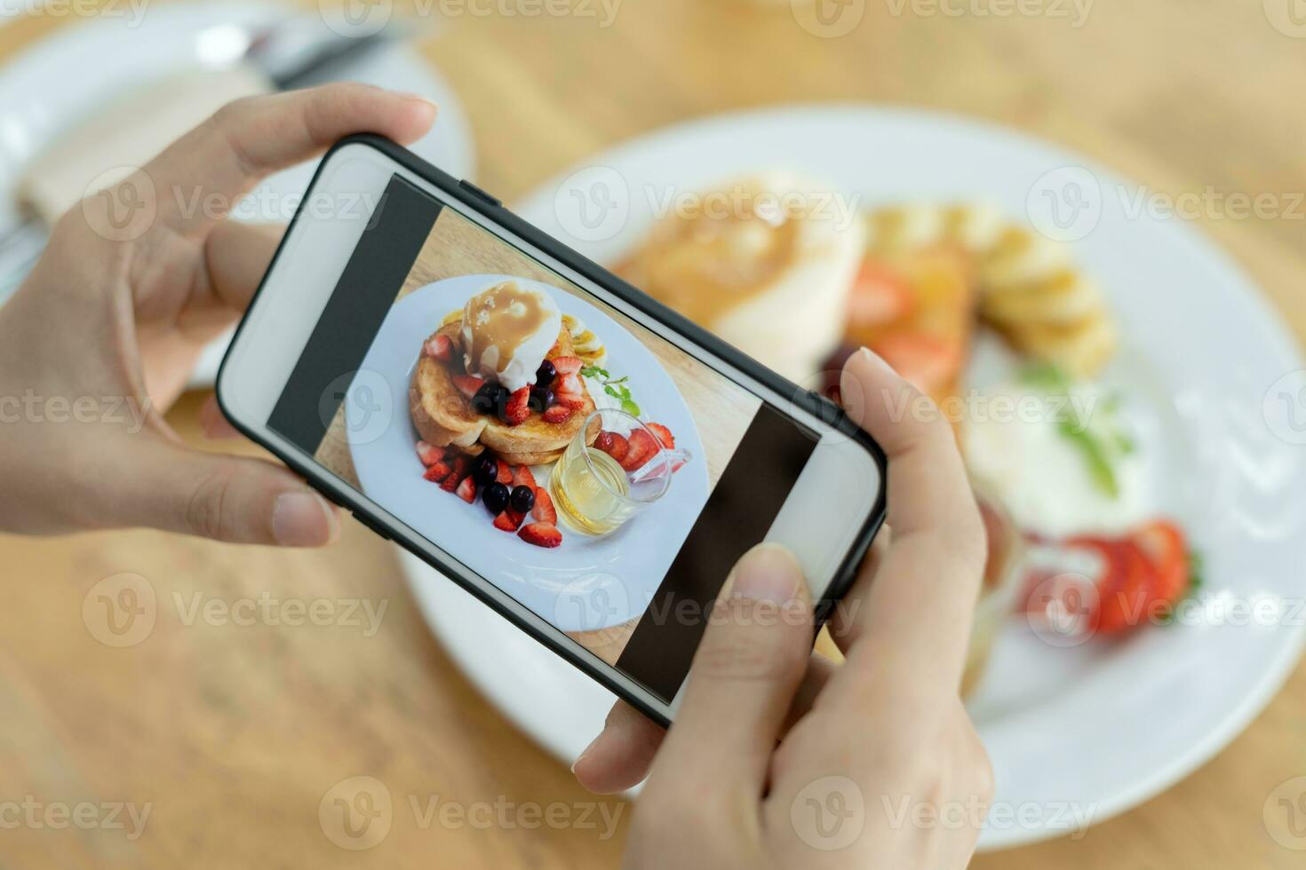 restaurant eigenaar duurt een afbeelding van de voedsel Aan de tafel met een smartphone naar post Aan een website. online voedsel levering, bestellen onderhoud, beïnvloeder, opnieuw bekijken, sociaal media, deel, marketing, interesse. foto