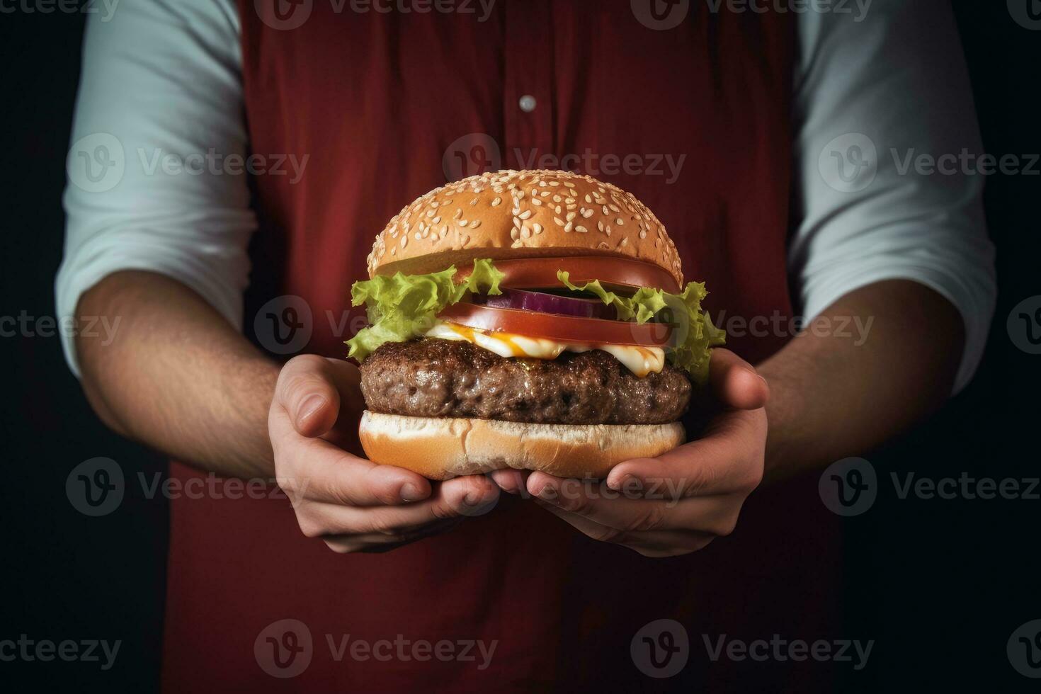 de koken houdt een Hamburger in zijn handen. foto