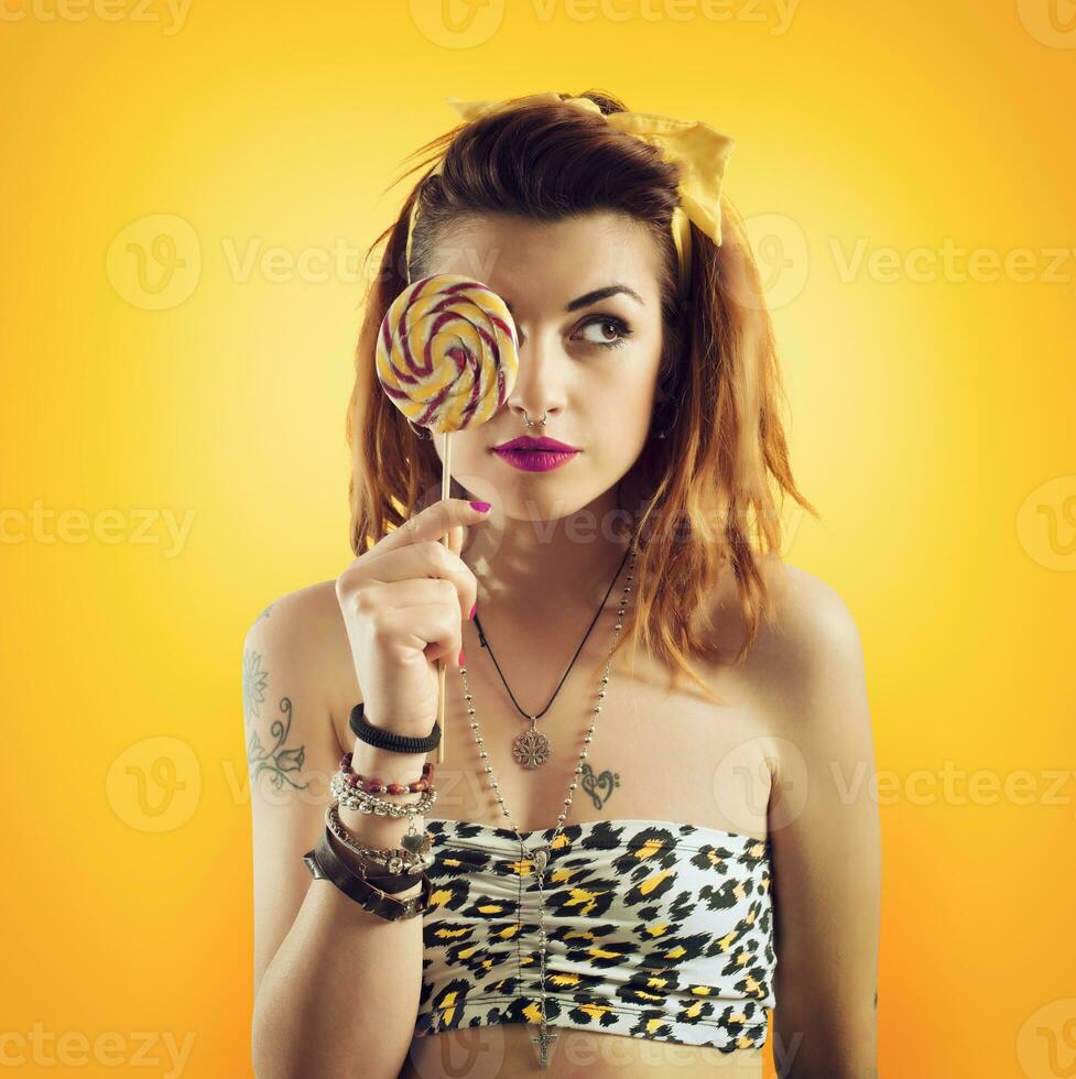 jong vrouw aan het eten lolly in geel stijl foto