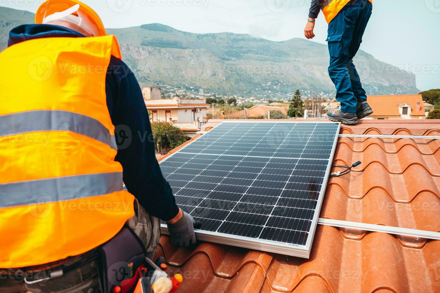 arbeiders monteren energie systeem met zonne- paneel voor elektriciteit en heet water foto