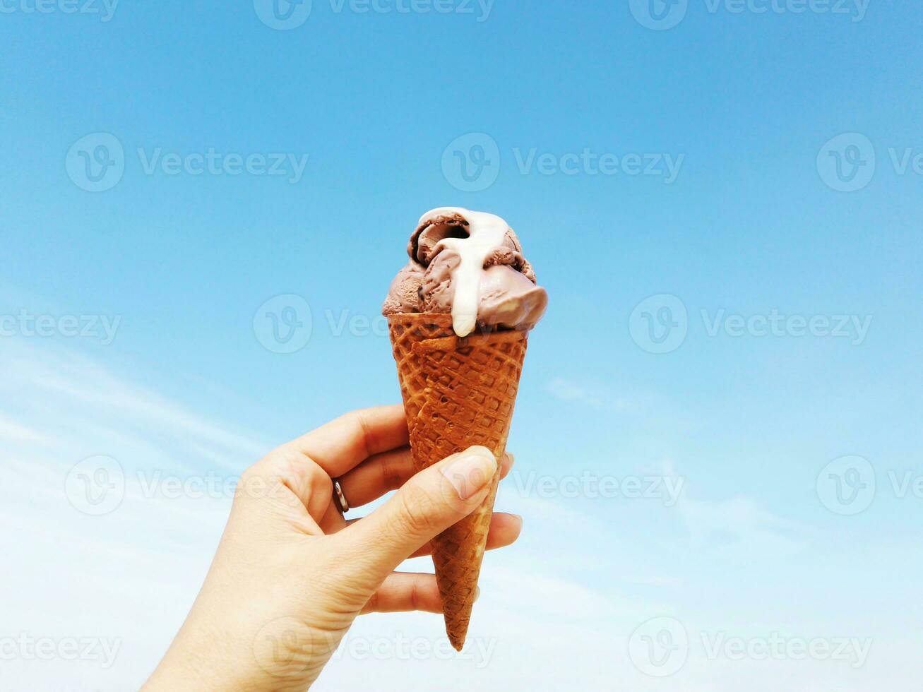 vrouw hand- Holding wafel ijshoorntje van chocola ijs room foto