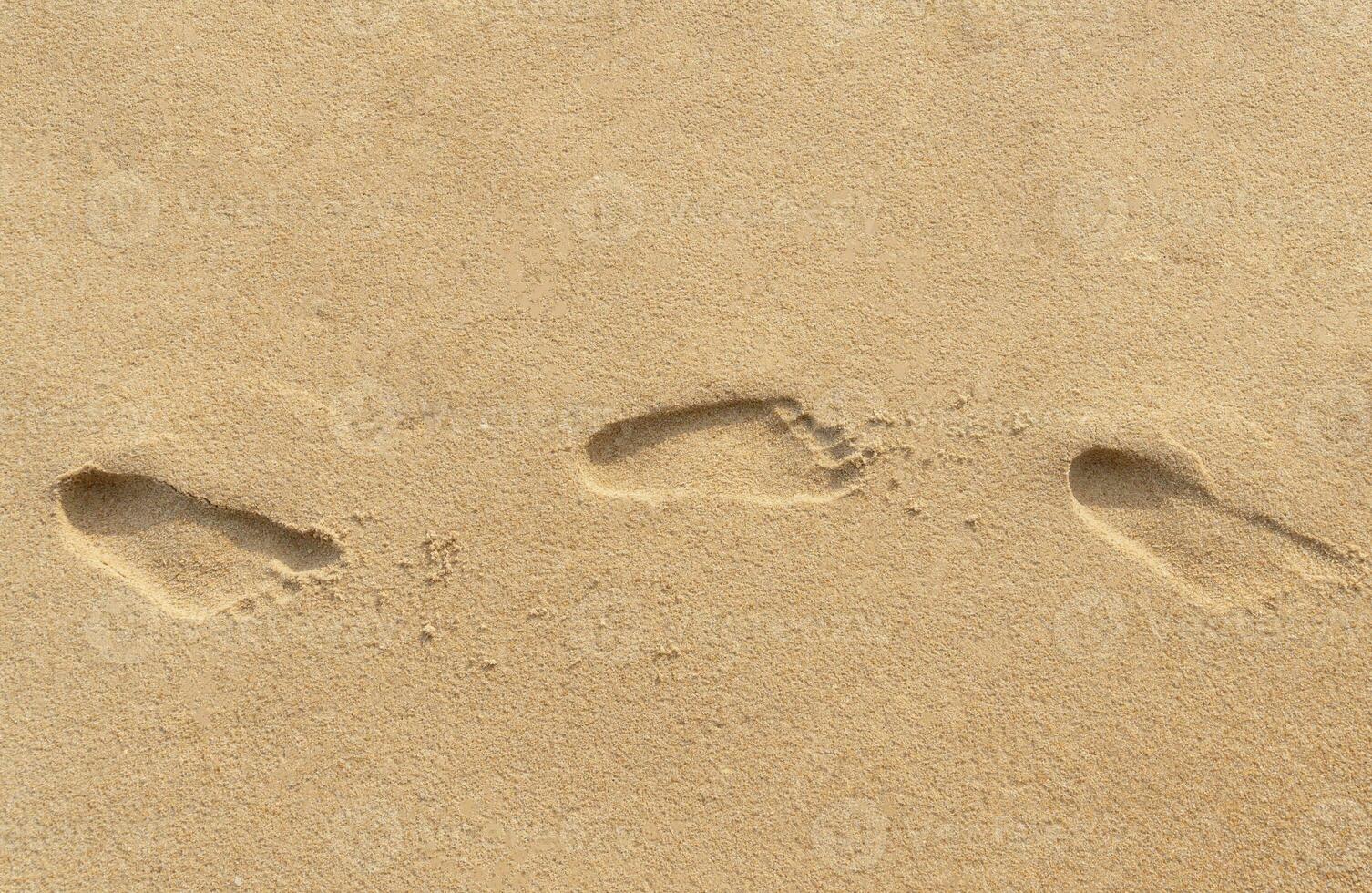 klein kind voetafdrukken Aan bruin zand Bij de strand foto