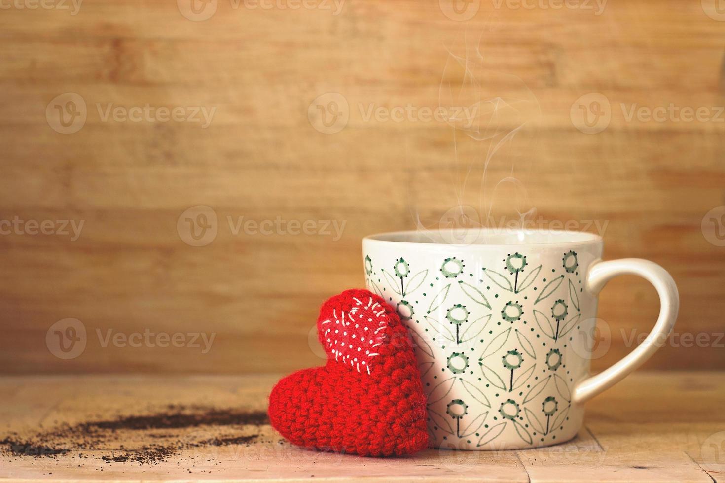 koffie in een kopje, met klein rood hart, op houten achtergrond foto