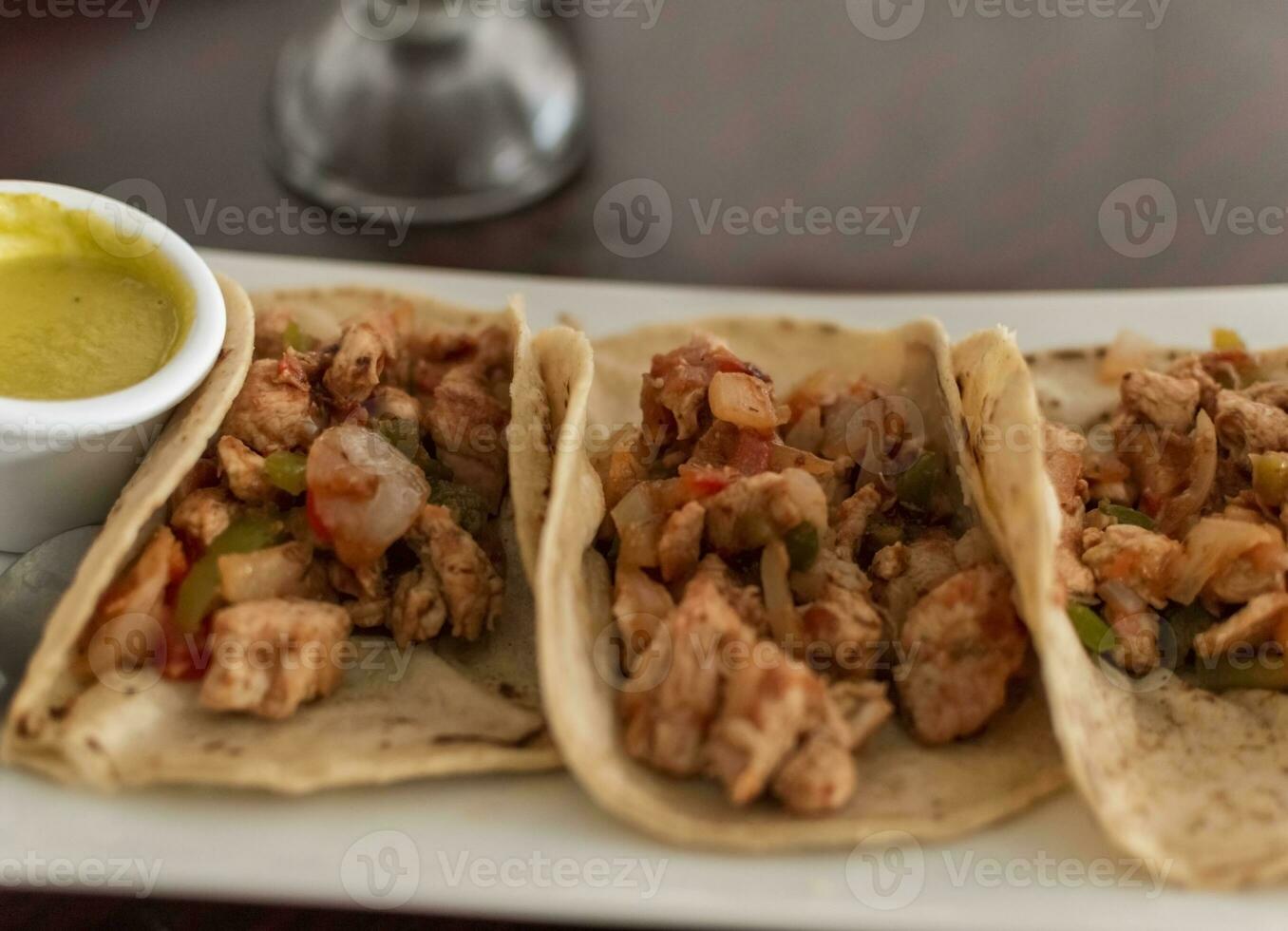 Mexicaans taco's al voorganger geserveerd met heet saus, heerlijk Mexicaans kip taco's met salsa en pico de gallo geserveerd Aan de tafel, visie van kip taco's geserveerd Aan de tafel foto