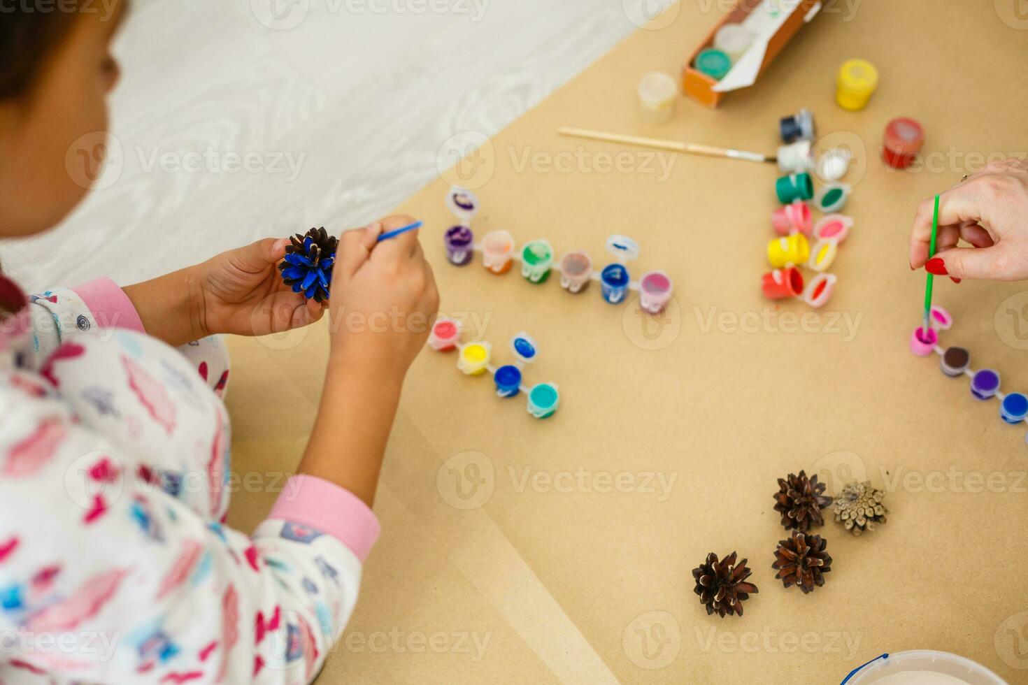 schattig weinig meisje kleur een natuurlijk ijshoorntje Spar naar creëren een bloem, reeks van borstels, verven, natuurlijk herfst materialen, creëren pret en gemakkelijk met kinderen, diy voor kleuterschool foto