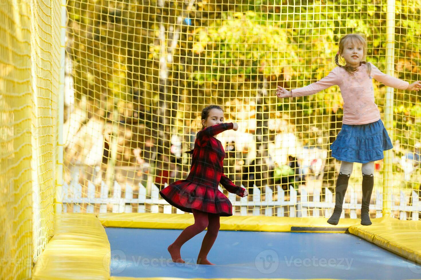 weinig meisjes hebben pret net zo ze springen Aan trampoline foto