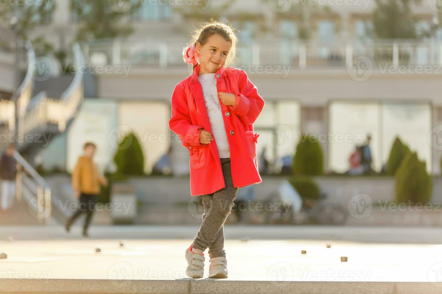 schattig weinig meisje vervelend rood jas en wit sportschoenen. mode concept foto