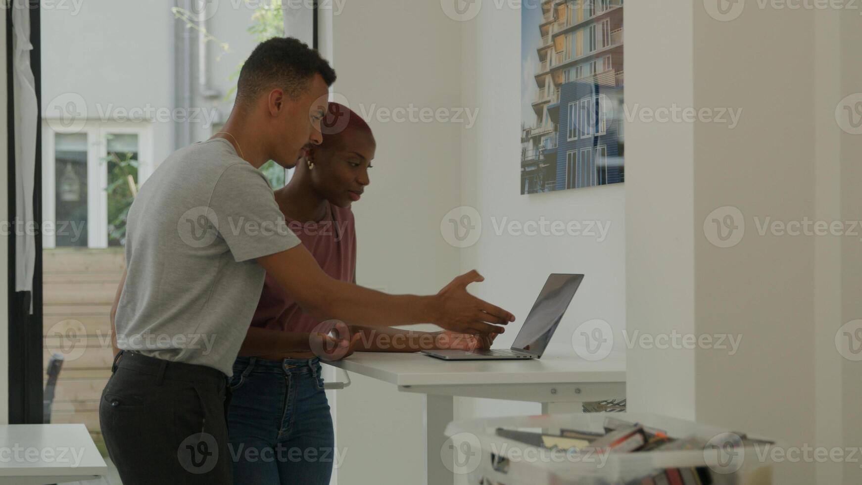 jonge vrouw met behulp van laptop en bespreken met mannelijke collega foto