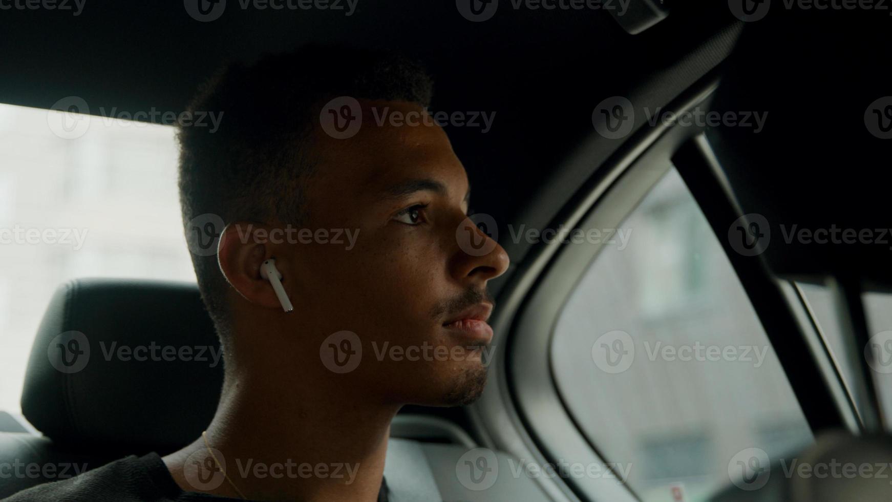 jonge man zit achter in de cabine oortelefoons in te zetten foto