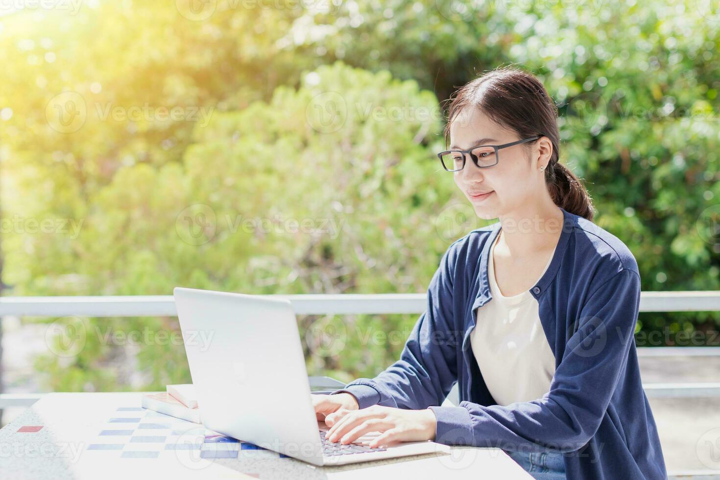 Universiteit tiener Aziatisch jong vrouw zittend onderwijs aan het leren typen laptop computer met groen boom achtergrond. foto