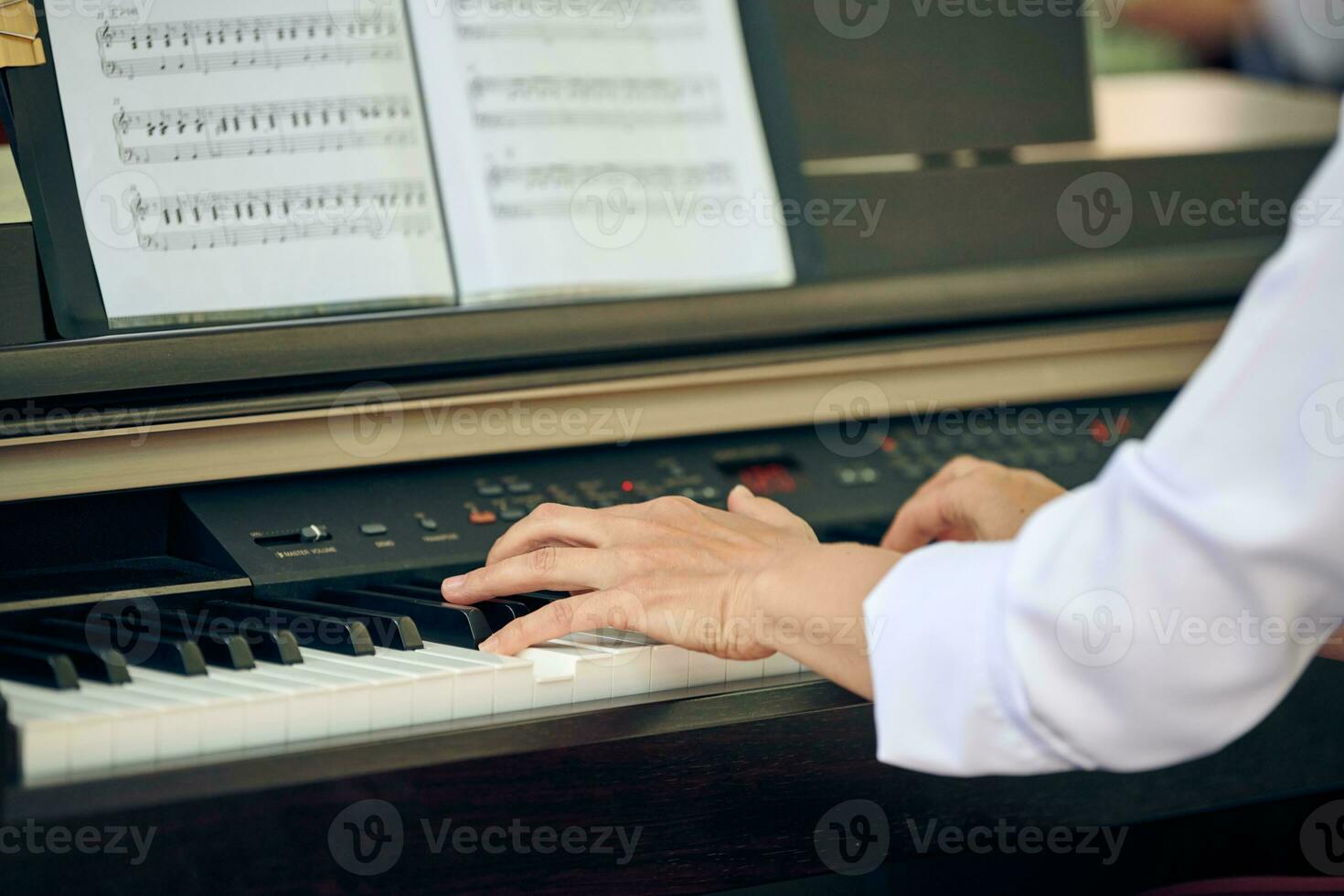 vrouw Toneelstukken elektrisch piano Bij buitenshuis muziek- prestatie, dichtbij omhoog visie naar behendig handen foto