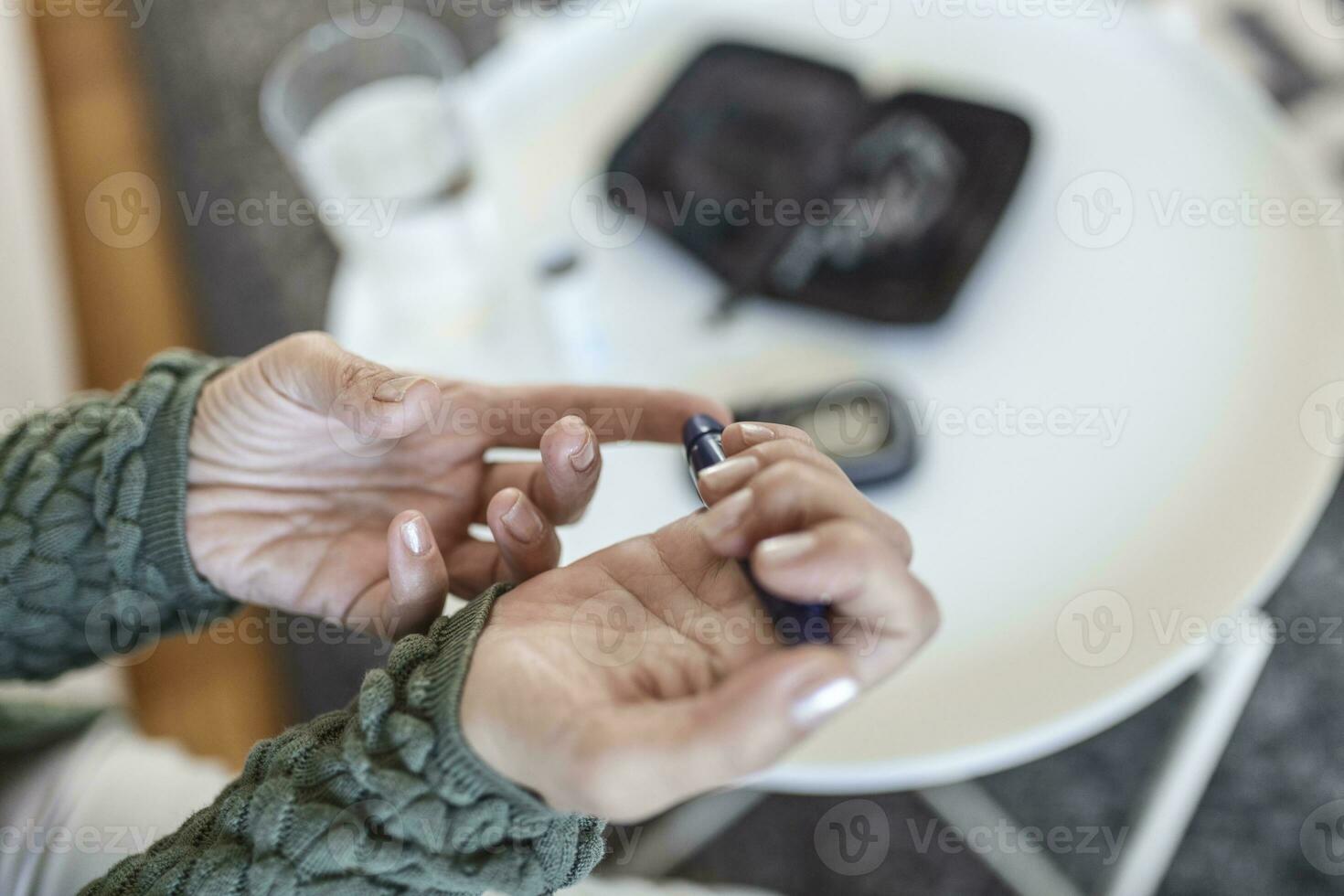 test bloed glucose voor diabetes in senior vrouw met glucosemeter. een rood laten vallen van bloed Aan de vinger klaar naar meten suiker niveau. dichtbij omhoog van mannetje vinger met bloed laten vallen en test streep foto