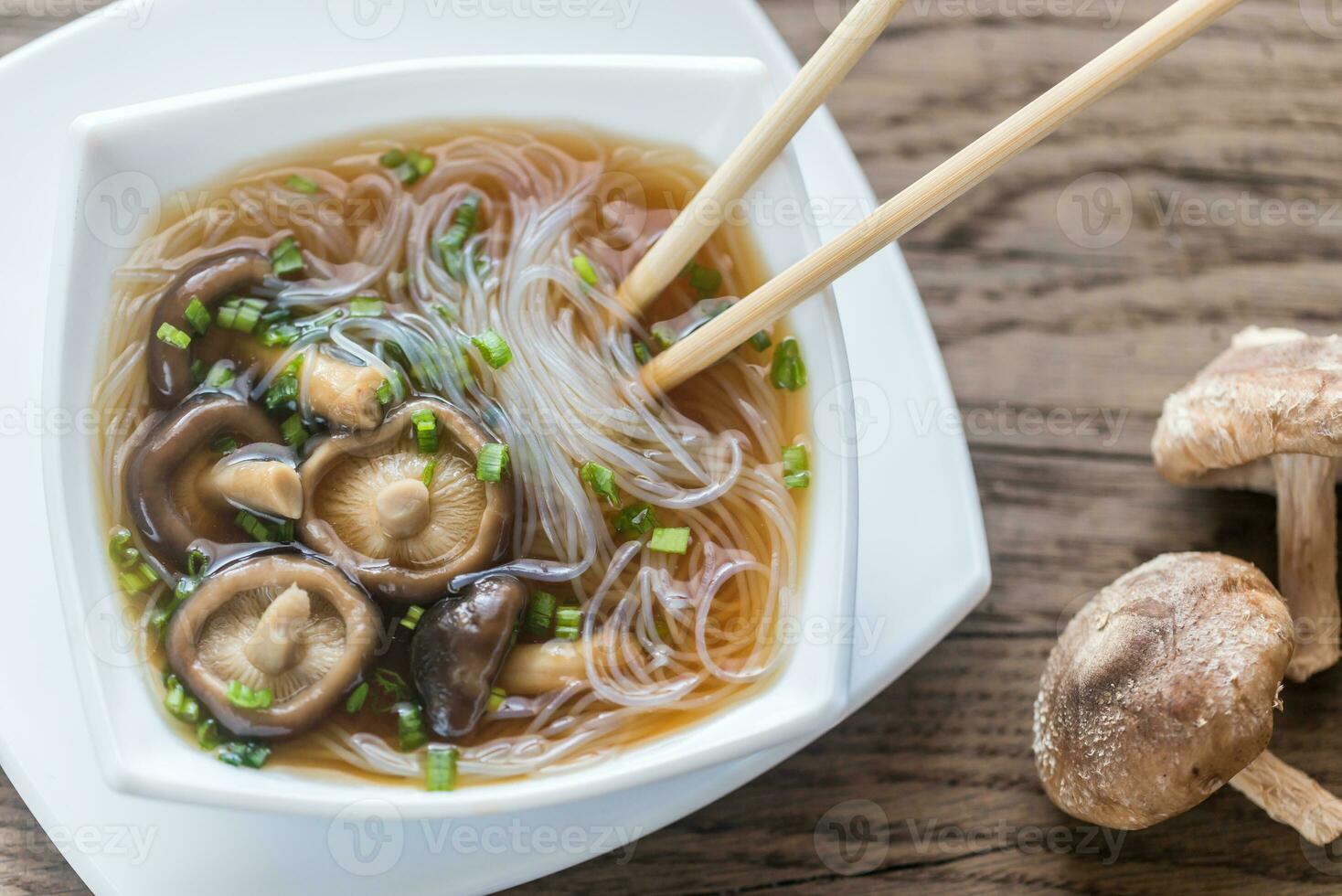 kom van shiitake soep Aan de houten tafel foto