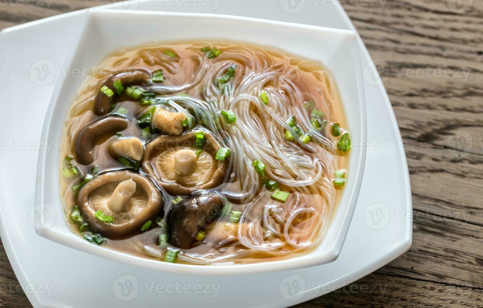 kom van shiitake soep Aan de houten tafel foto