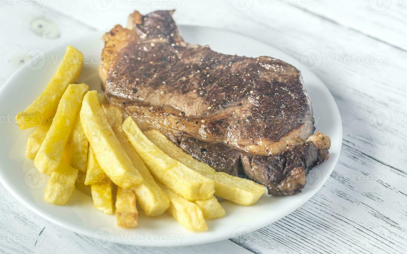 rundvlees steak met gebakken aardappelen Aan de bord foto