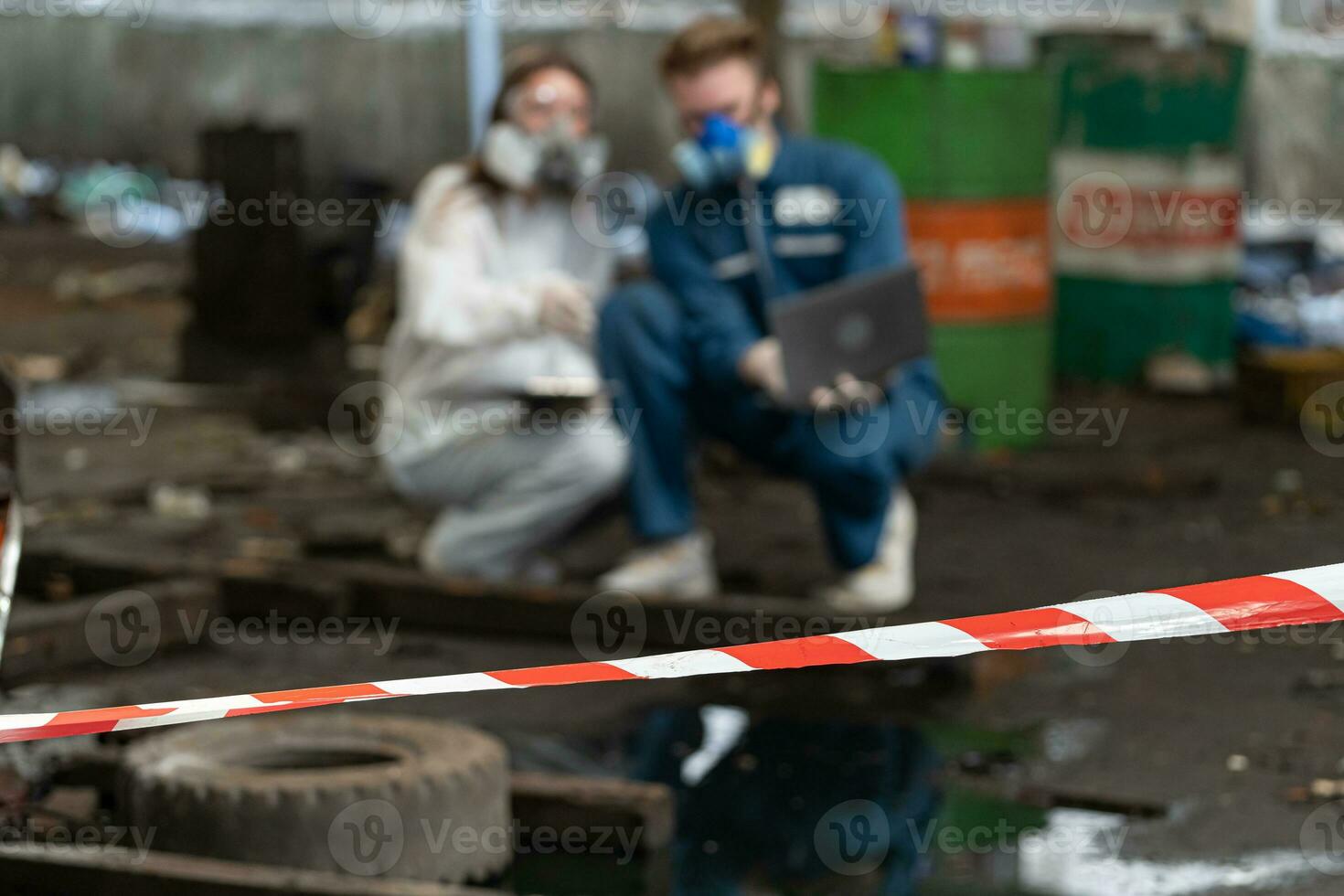 noodgeval verontreiniging fabriek concept. ingenieurs vervelend monteur jumpsuits en ppe en gas- maskers inspecteren olie Aan de fabriek vloer. foto