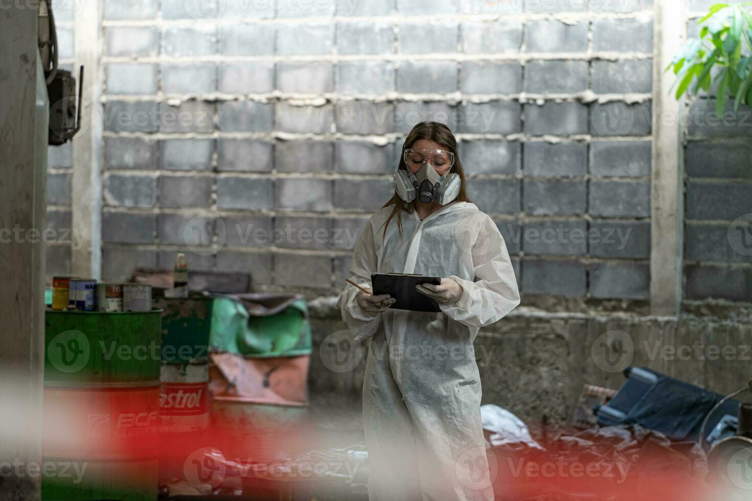 noodgeval verontreiniging fabriek concept. vrouw chemicus vervelend ppe en gas- masker inspecteren olie Aan fabriek verdieping foto