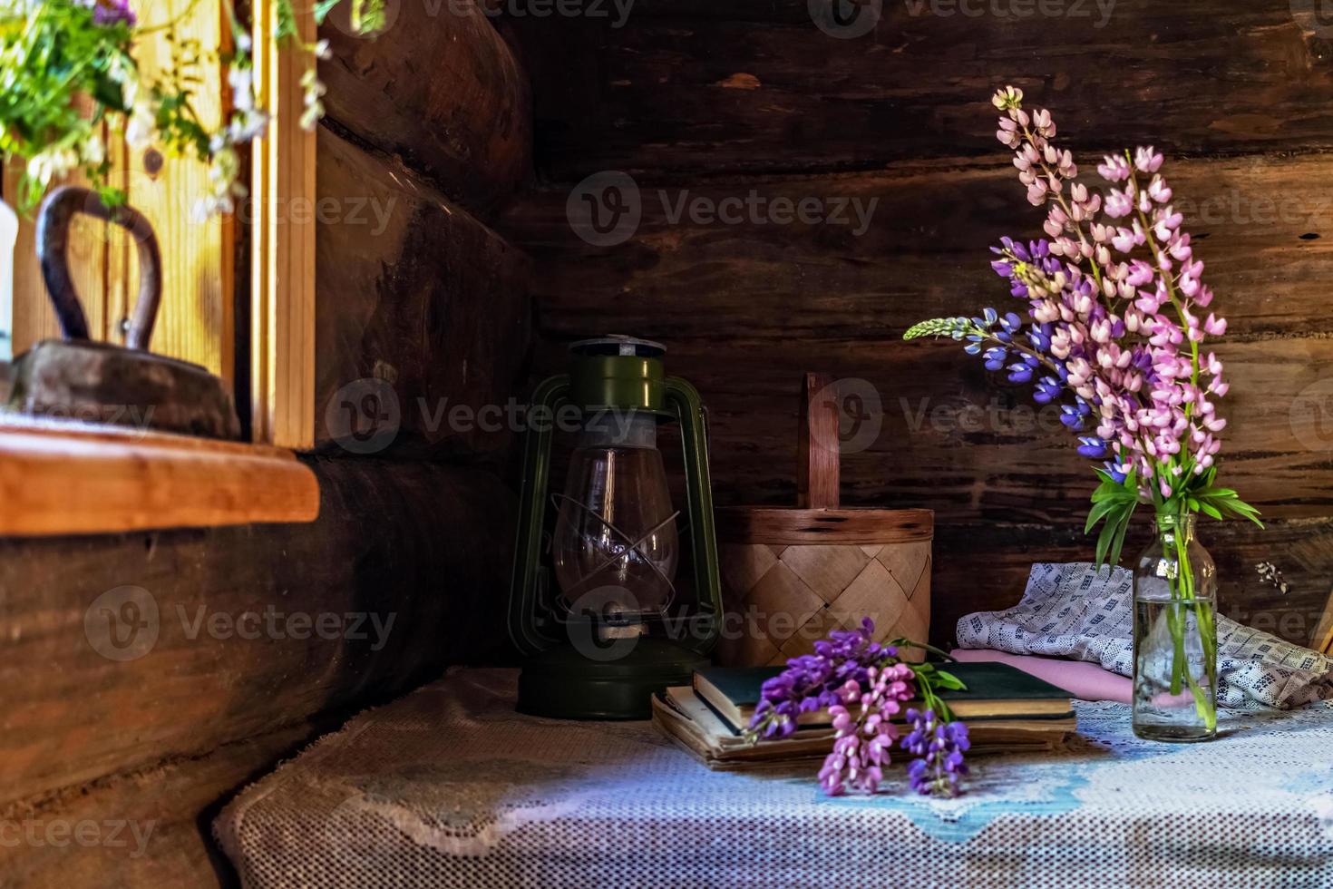 stilleven van vintage items en een boeket lupines op een tafel bij het raam in een oud dorpshuis. foto