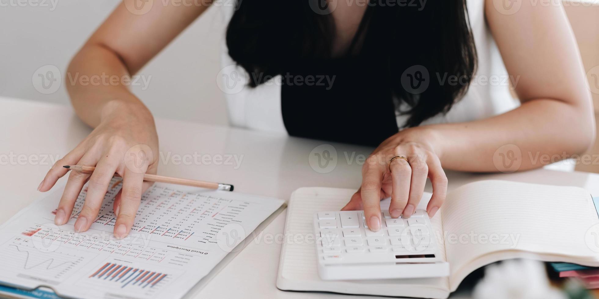 close-up zakenman met behulp van rekenmachine en laptop voor het berekenen van financiën, belastingen, boekhouding, statistiek en analytisch onderzoeksconcept foto